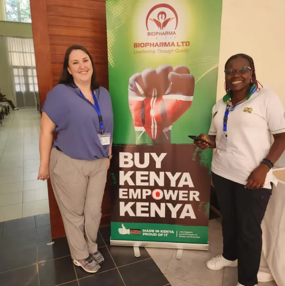 two employees standing in front of bipharma poster